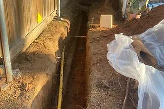 Exterior trench prepared for plumbing pipe